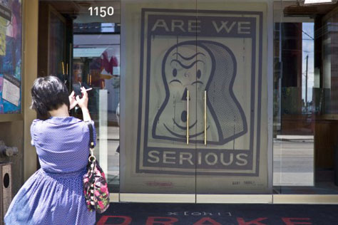 A vinyl installation of Gary Taxali's work Are We Serious (2009) on the doors of Toronto's Drake Hotel.